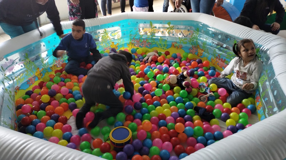 Niños en situación de discapacidad auditiva juegan en piscina de peloas
