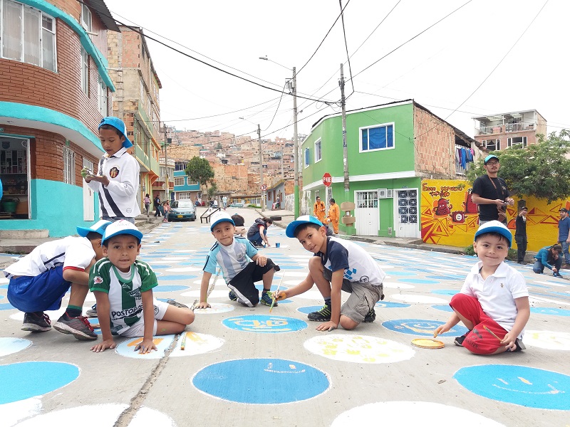 Niños pintando el piso, felices