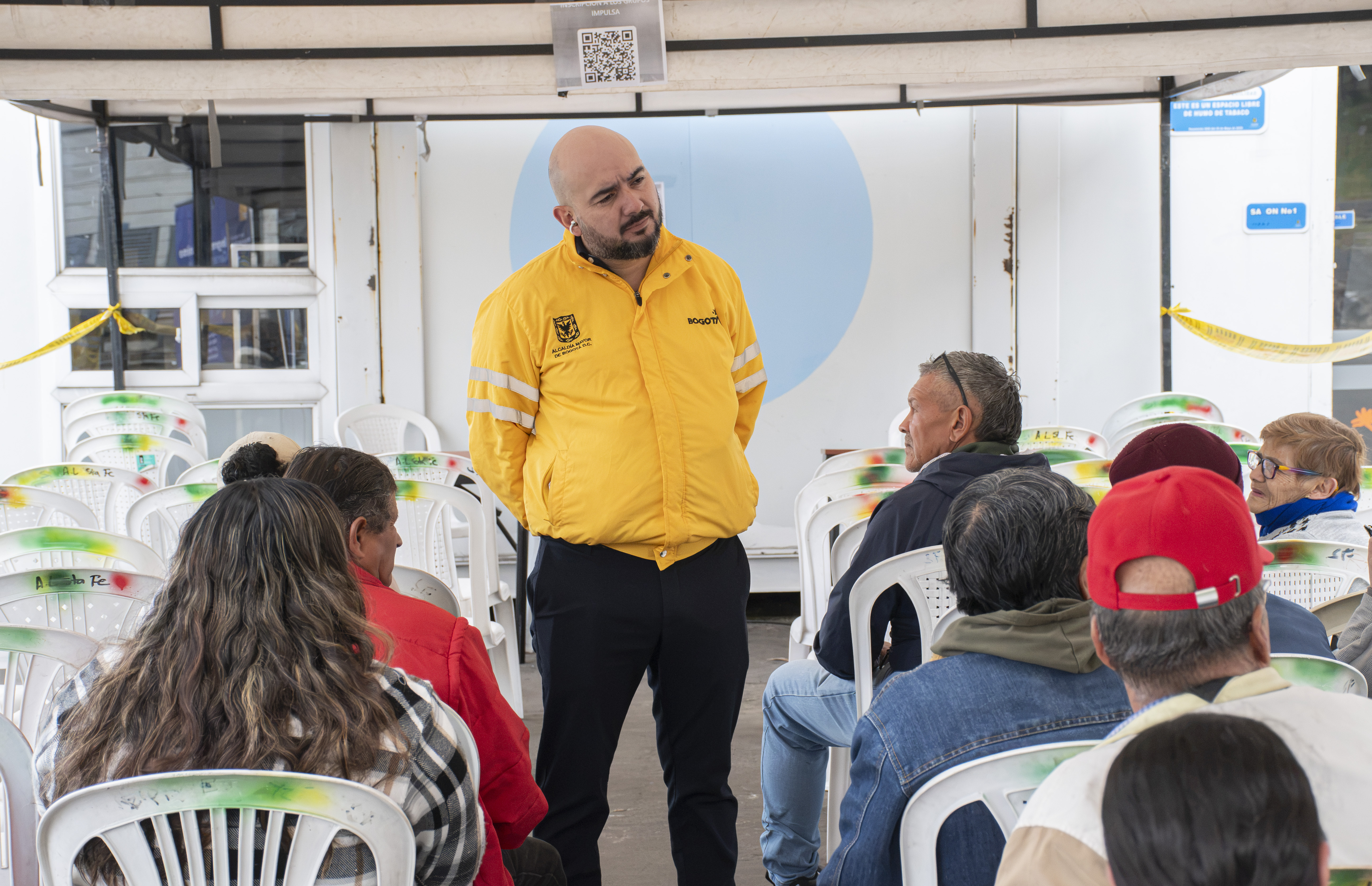 Foto personas sentadas en un auditorio recibiendo información de un señor que está de pie
