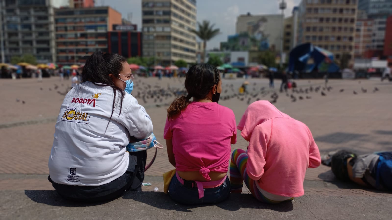 foto de funcionaria hablandoles a niños en la calle