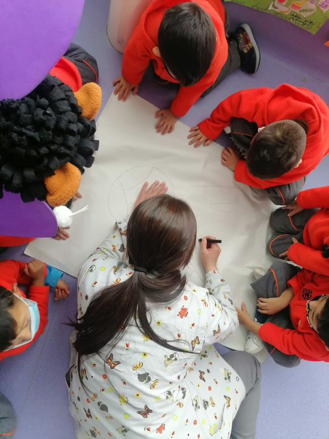 foto de niños dibujando con profesora