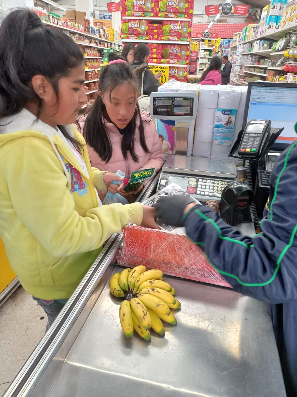 mujeres pagando en caja registradora