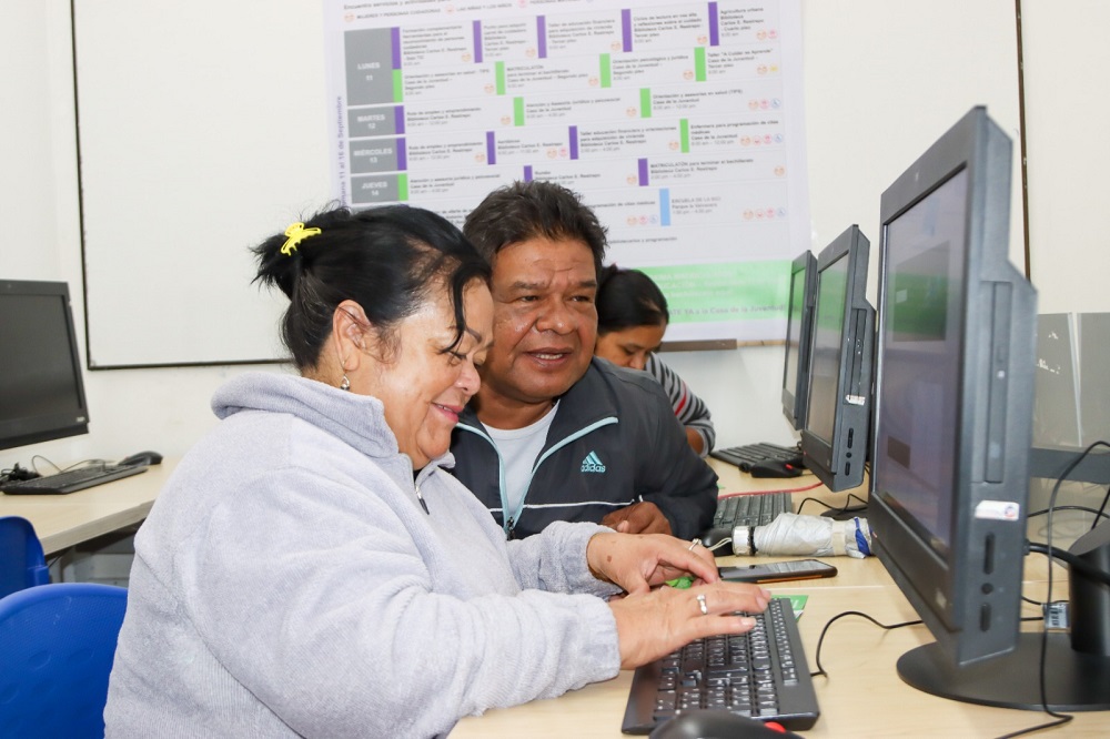 mujer estudiando con computador al frente de ela