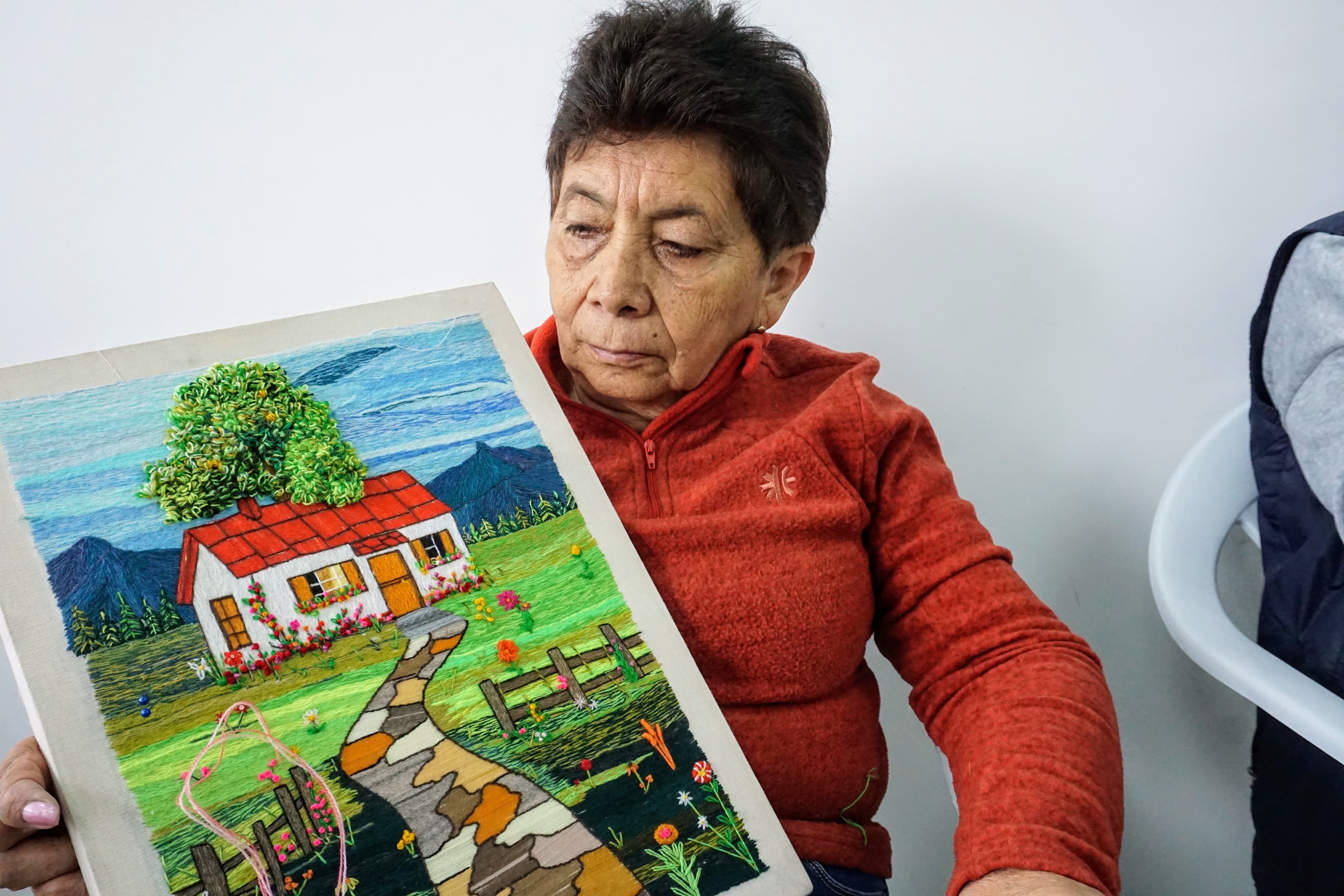 Foto mujer mostrando su obra tejida
