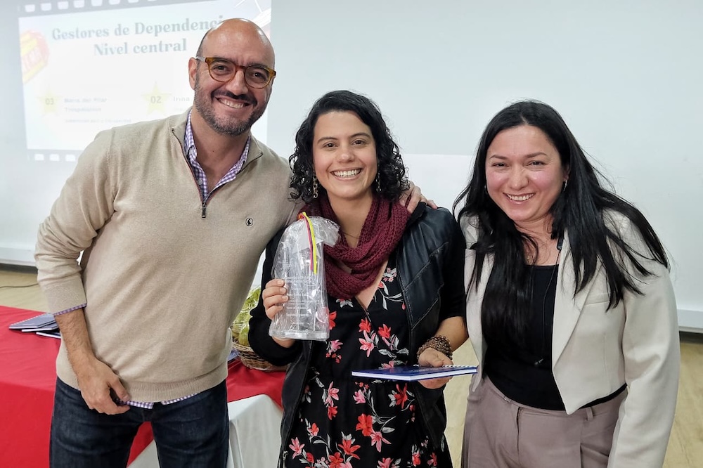 foto de director de direccion de analisis y diseño estrategico entregando reconocimiento a funcionaria