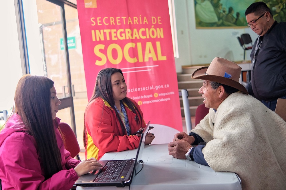 Foto funcionarios de la secretaria hablando con hombre campesino