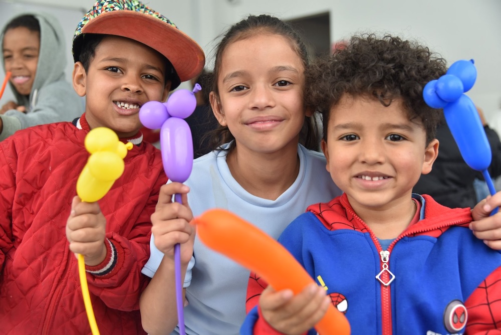 foto de dos niños y una niña con figuras realizadas con globos