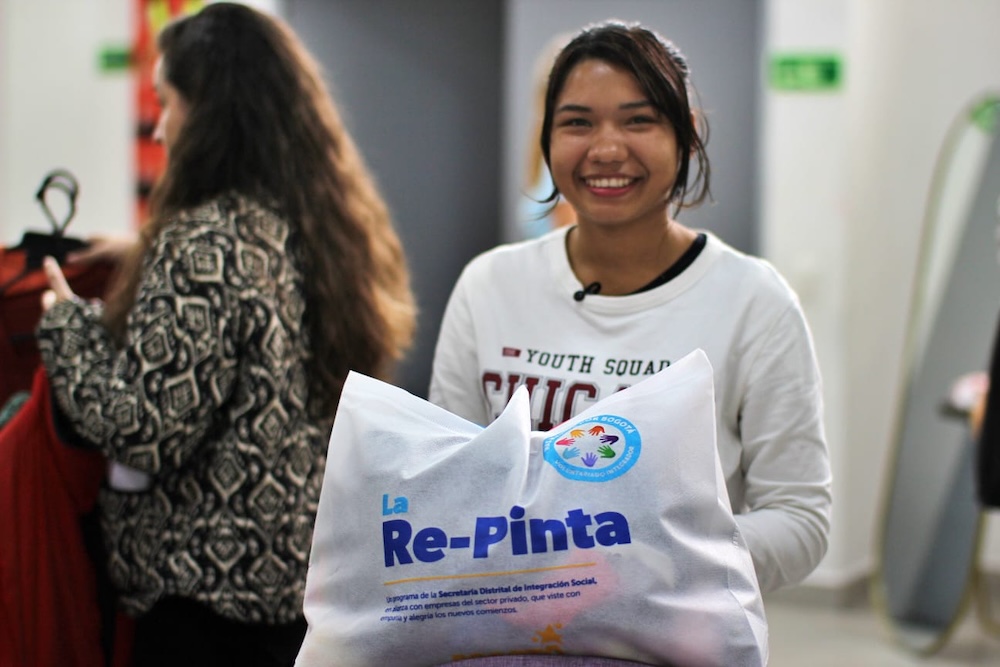 foto de mujer sonriendo con bolsa de la re-pinta en la mano
