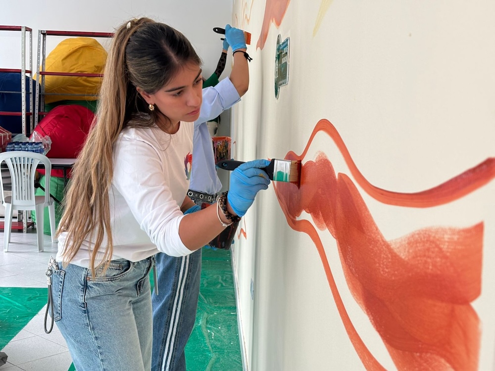 mujer joven pintando pared