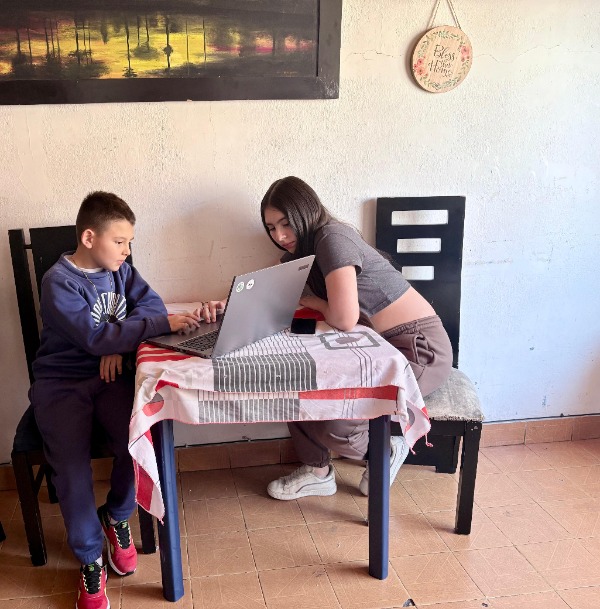 Foto de niños sentados frente a un computador