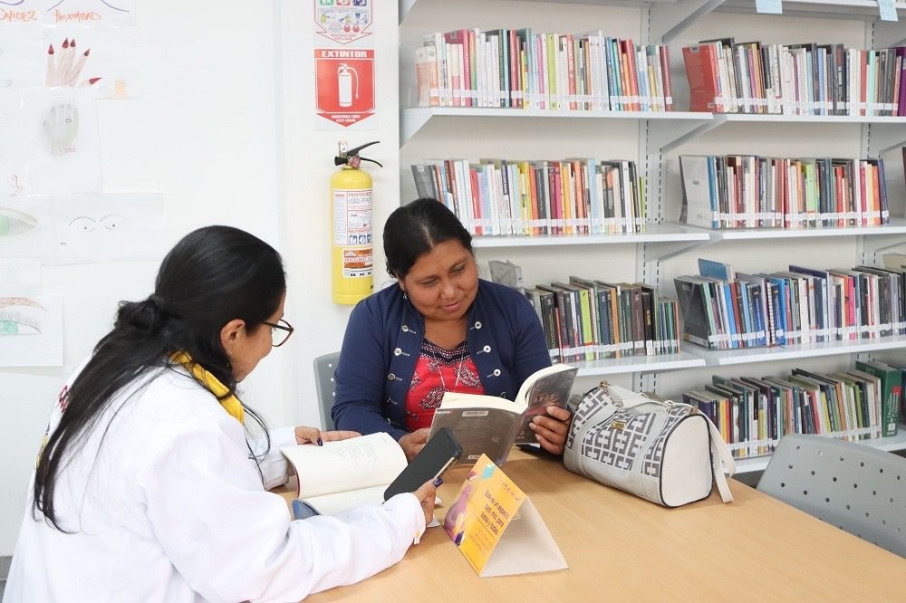 foto de mujer leyendo un libro en casa lgbti