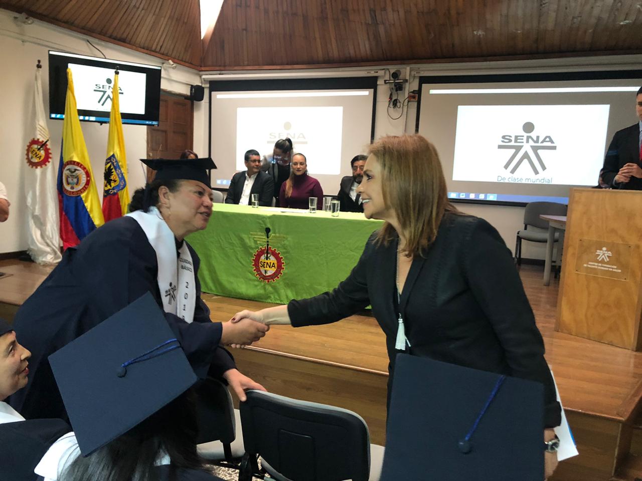 foto de secretaria dando mano a graduados