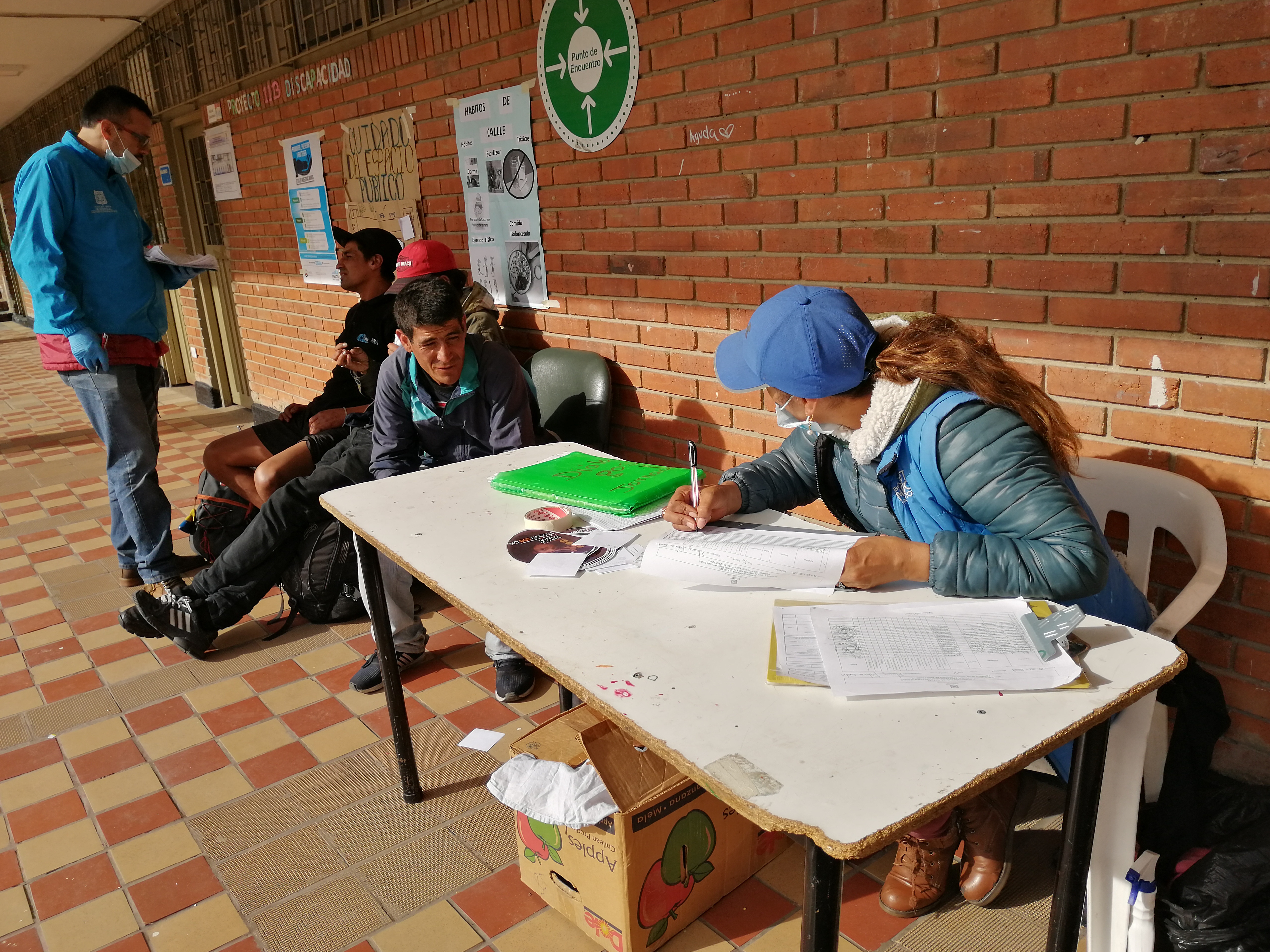 FOTO DE FUNCIONARIO CON HABITANTES DE CALLE