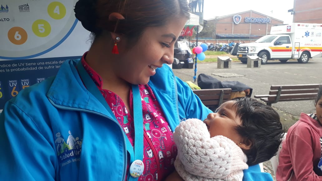 foto de funcionaria con niño de brazos
