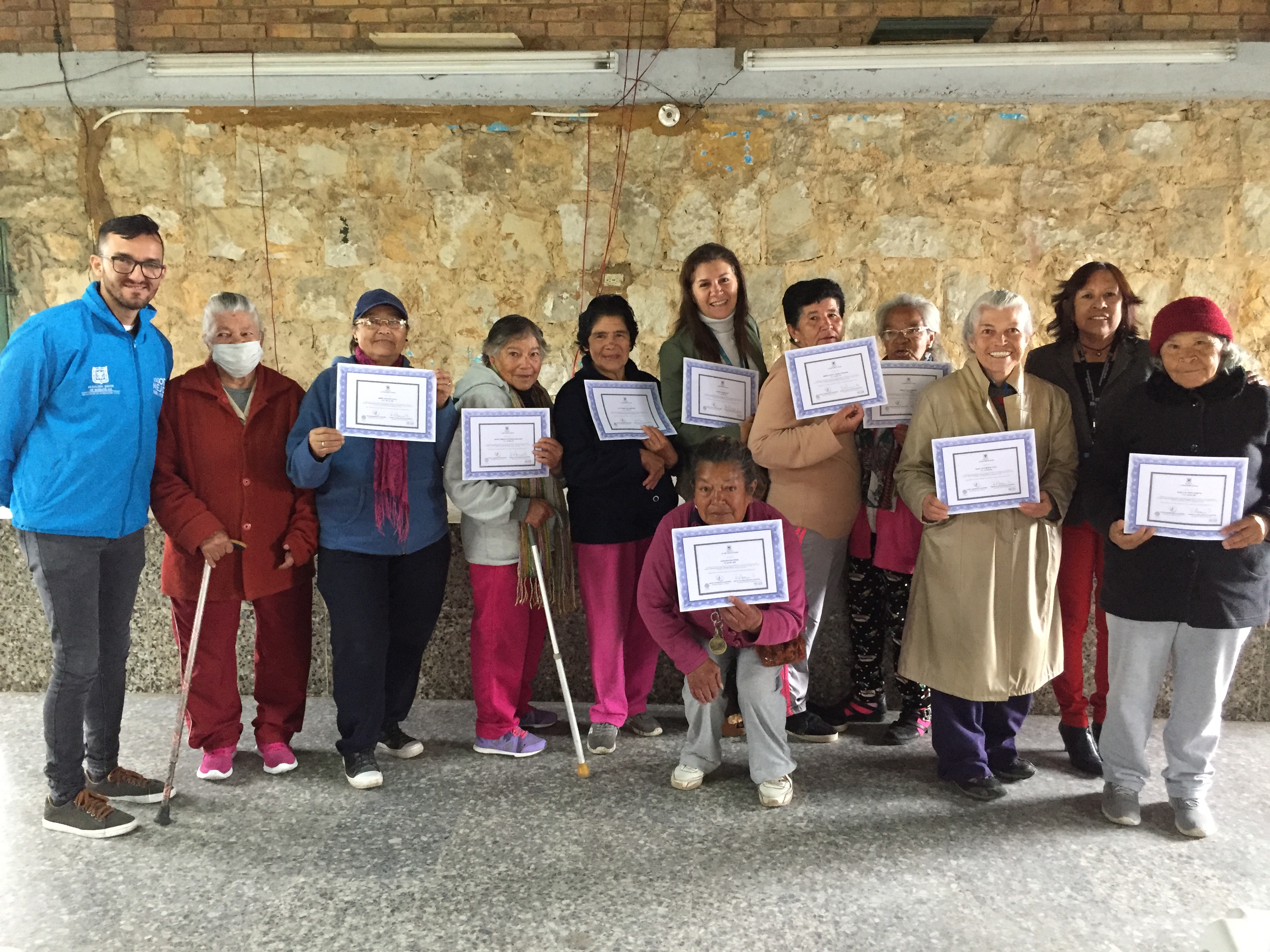 foto de funcionario y mujeres mayores con diplomas