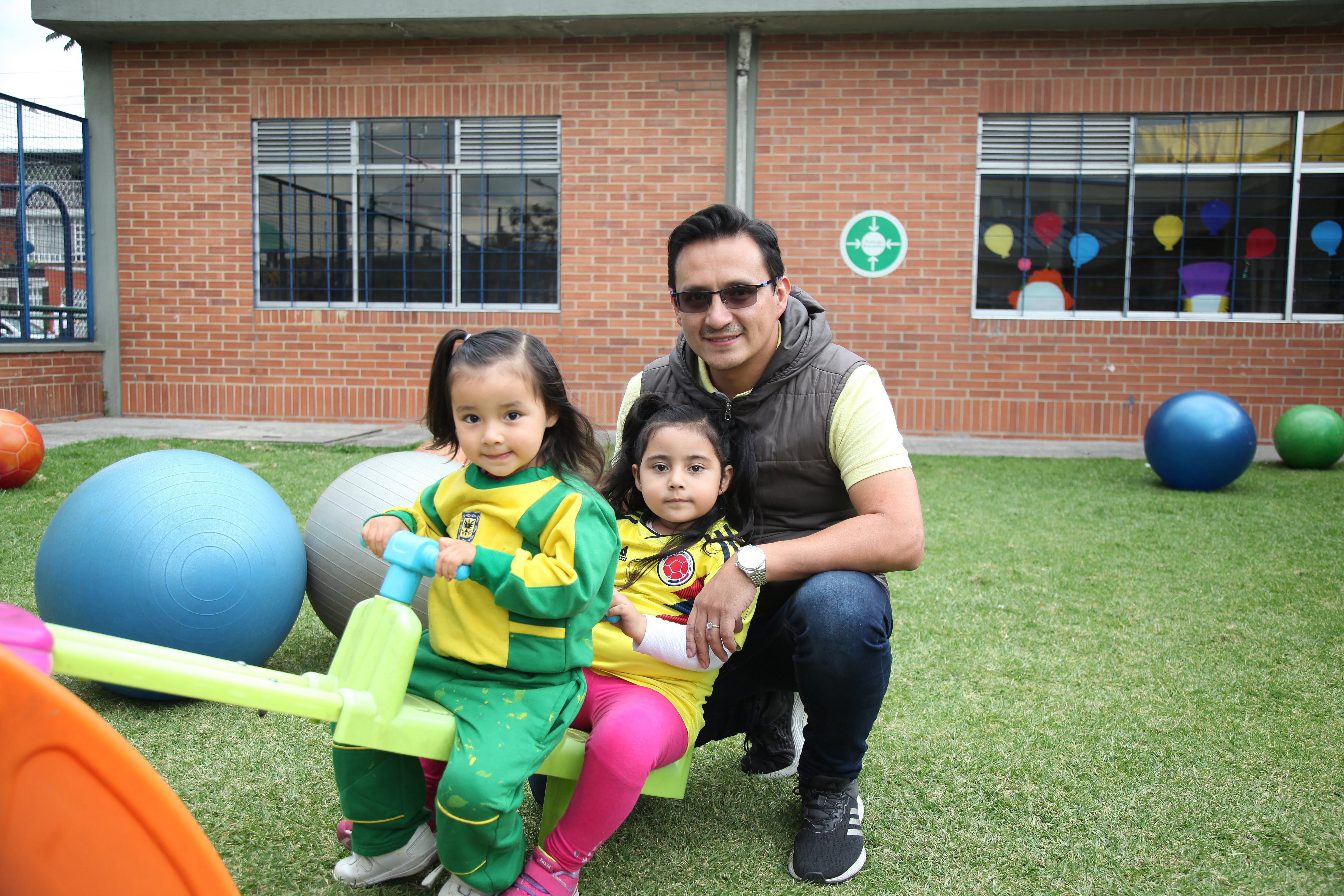 foto de padre con sus 2 hijas en el parque