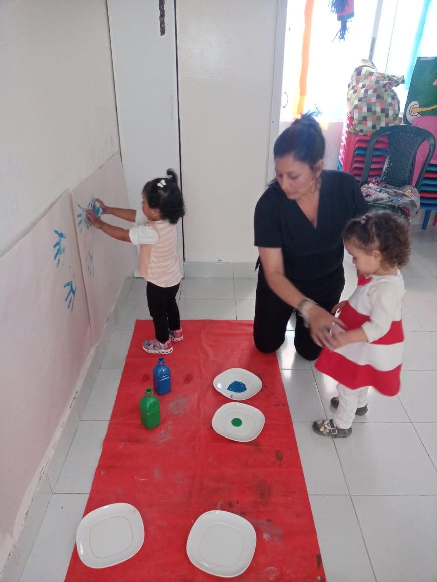 foto de profesora cuidando a niños y niñas