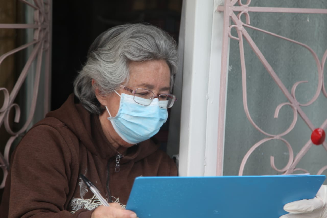 foto de mujer mayor en la puerta de su casa